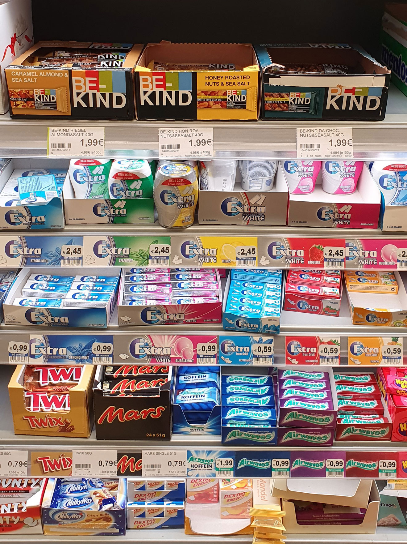 Foto: BE-KIND Riegel im Süßwarenregal neben Mars, Twix und Kaugummis platziert.