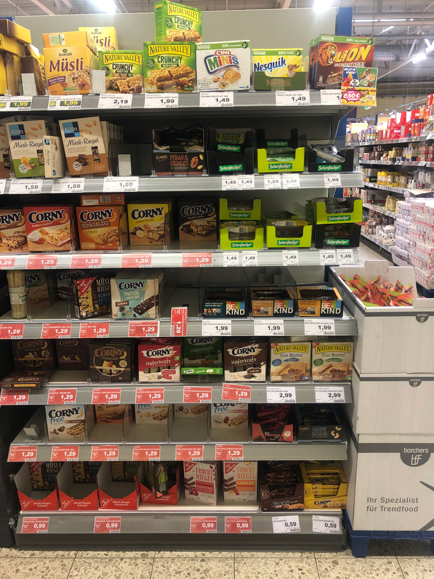Foto: BE-KIND Riegel im Süßwarenregal neben Mars, Twix und Kaugummis platziert.