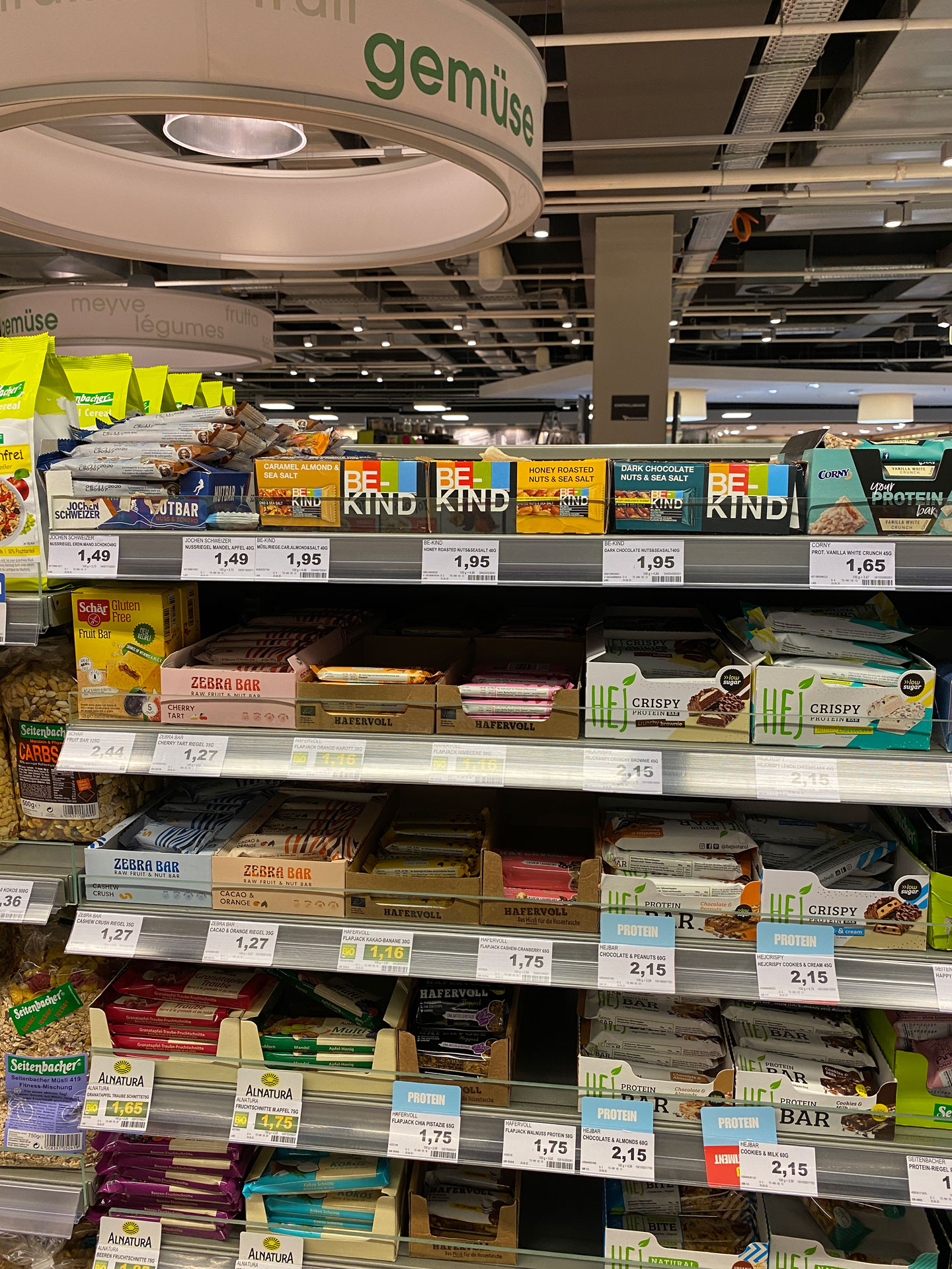 Foto: BE-KIND Riegel im Süßwarenregal neben Mars, Twix und Kaugummis platziert.