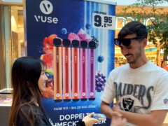 Teamgespräch und Touchpoint Situation zeigen die persönliche Ansprache im Retail Umfeld. Teamgespräch an einem BAT glo Touchpoint im Mall Umfeld